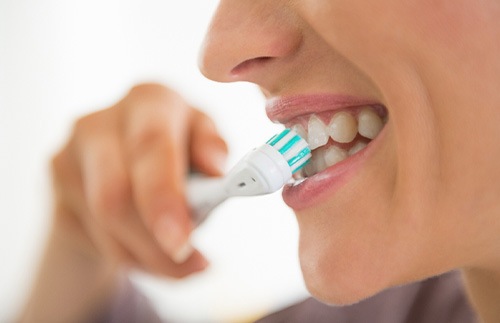 A closeup of a young woman brushing her teeth