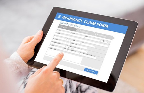 Person filling out insurance claim on tablet