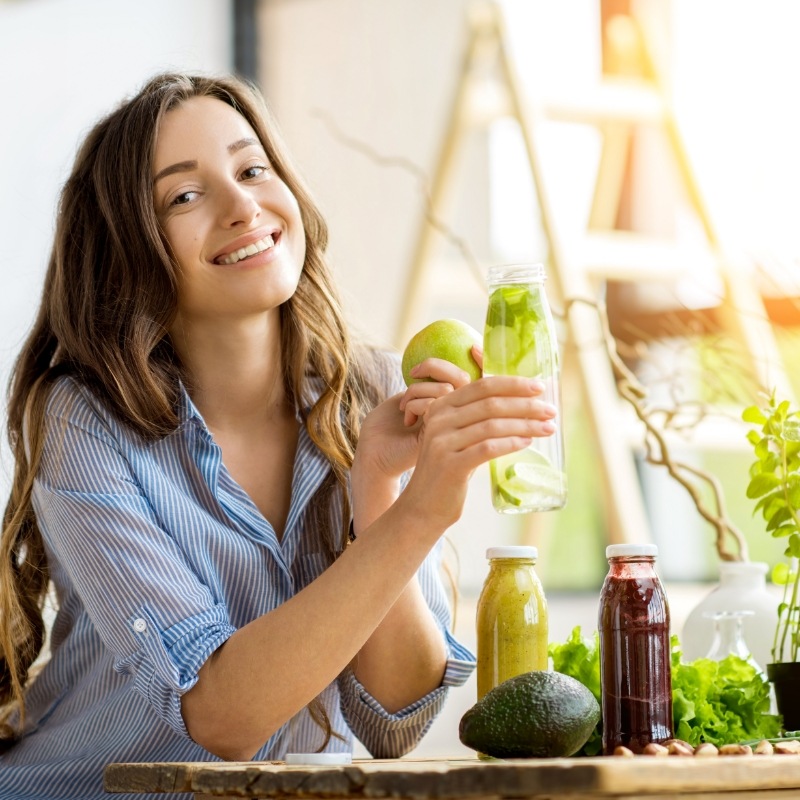 Woman holding an apple and some apple juice