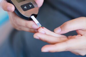 Person checking their blood sugar through finger stick.